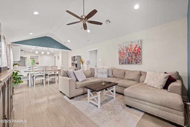 living room with ceiling fan, visible vents, vaulted ceiling, recessed lighting, and light wood-style flooring