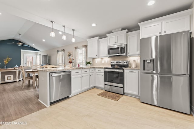 kitchen featuring a ceiling fan, stainless steel appliances, a peninsula, and a wealth of natural light