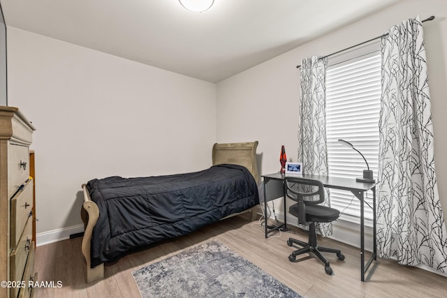 bedroom with baseboards and wood finished floors