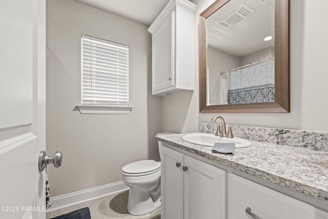 bathroom with a healthy amount of sunlight, vanity, baseboards, and visible vents