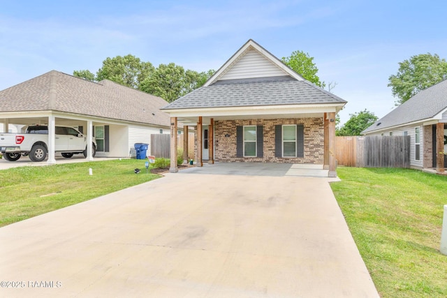 view of front of home with brick siding, fence, driveway, and a front yard
