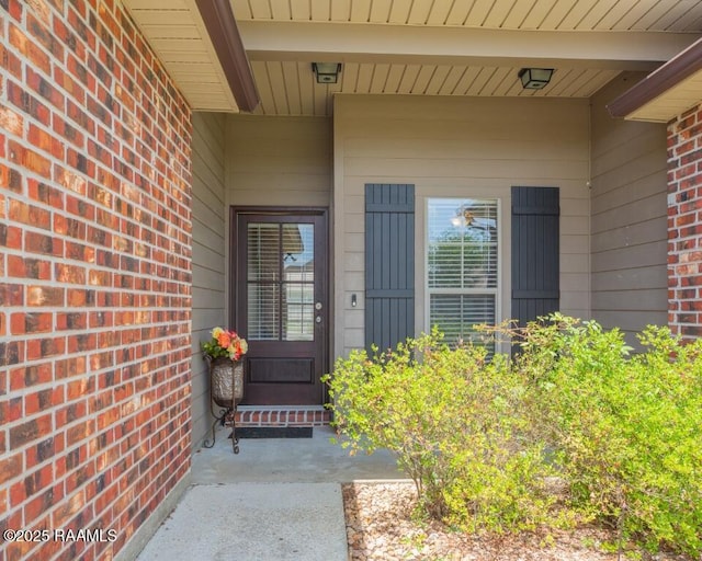 doorway to property featuring brick siding