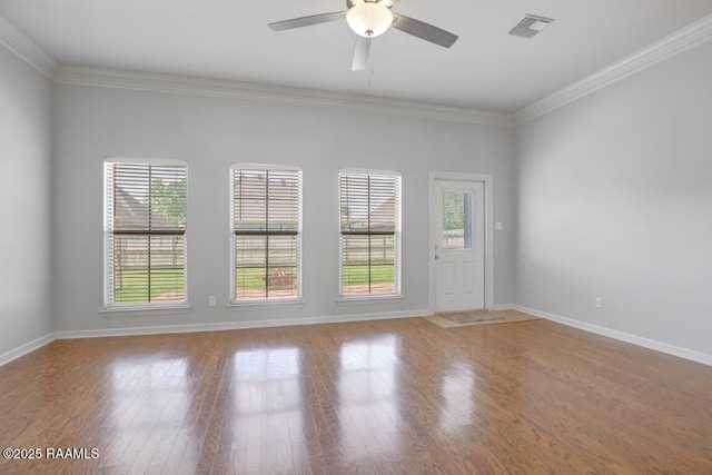 spare room with a ceiling fan, baseboards, visible vents, and ornamental molding