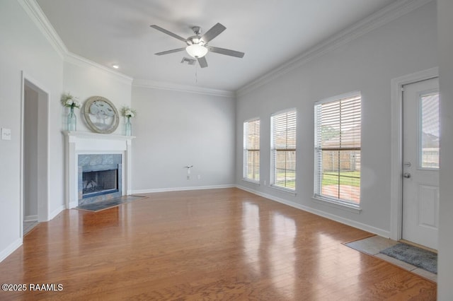 unfurnished living room with a ceiling fan, baseboards, ornamental molding, and wood finished floors