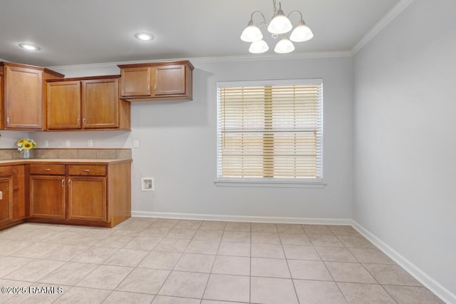 kitchen featuring brown cabinets, light countertops, a chandelier, pendant lighting, and ornamental molding