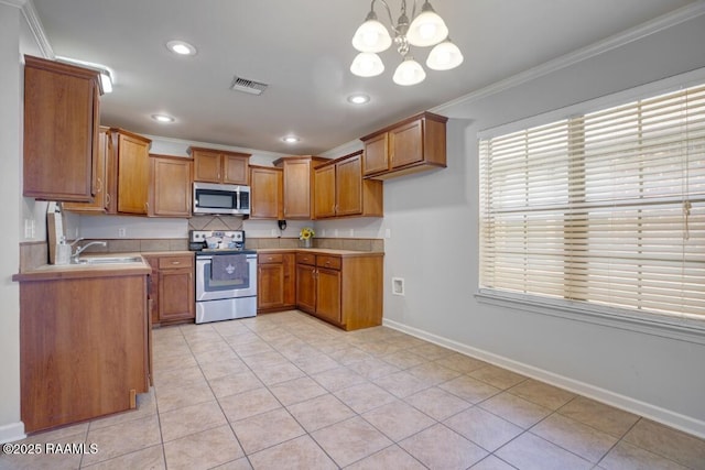 kitchen with visible vents, ornamental molding, brown cabinets, a sink, and stainless steel appliances
