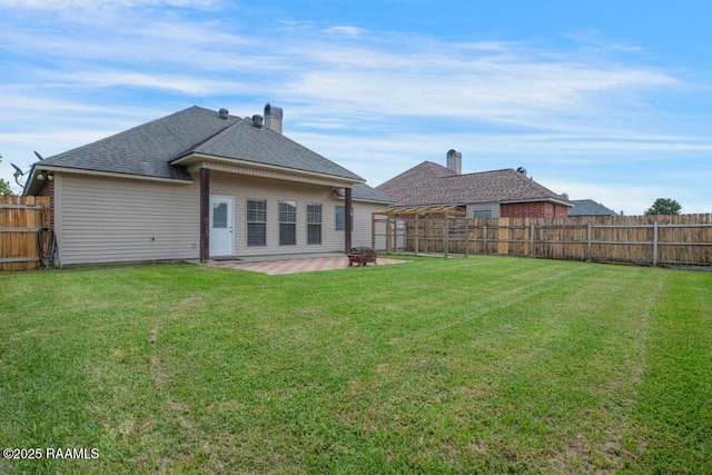 back of house featuring a fenced backyard, a patio, a shingled roof, and a yard