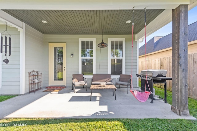 view of patio featuring area for grilling, covered porch, and fence