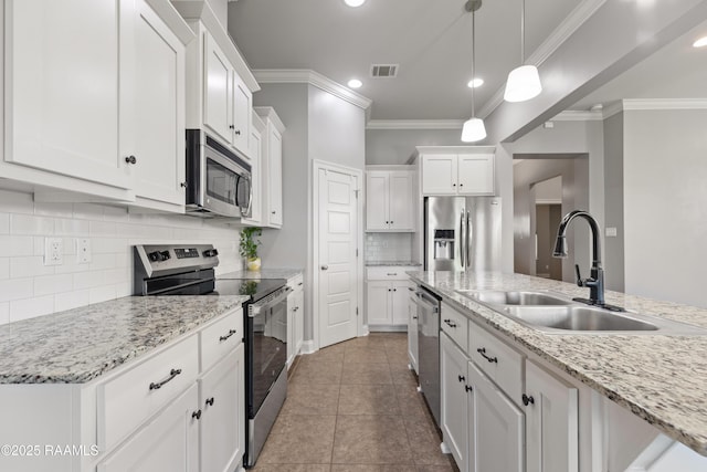 kitchen featuring appliances with stainless steel finishes, a sink, tasteful backsplash, ornamental molding, and white cabinets