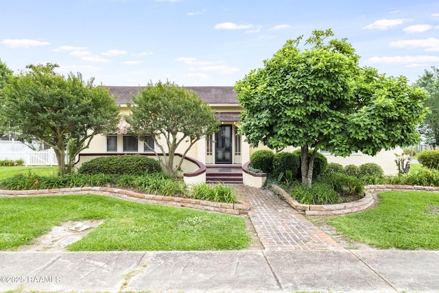 207 S Saint Valerie St, Abbeville, LA 70510 - view of front of house featuring stucco siding, a front yard, and fence