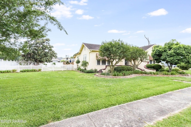 207 S Saint Valerie St, Abbeville, LA 70510 - view of side of home with fence, stucco siding, and a yard