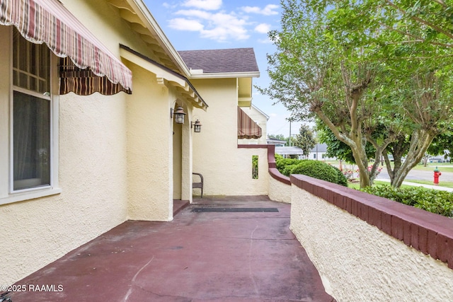 207 S Saint Valerie St, Abbeville, LA 70510 - view of home's exterior with a patio and stucco siding
