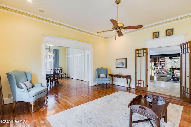 207 S Saint Valerie St, Abbeville, LA 70510 - living area with baseboards, ornamental molding, wood finished floors, and ceiling fan with notable chandelier