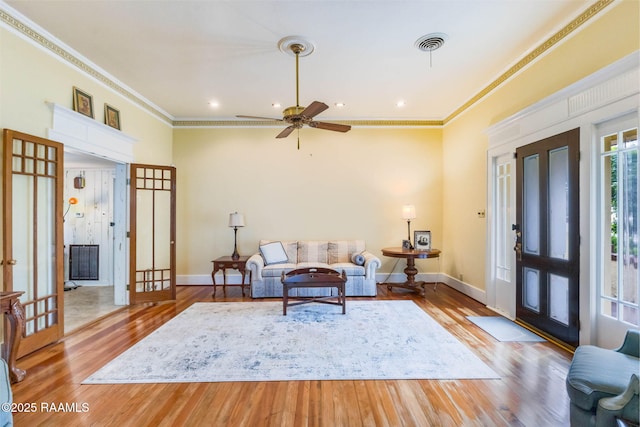 207 S Saint Valerie St, Abbeville, LA 70510 - living room with crown molding, baseboards, wood finished floors, and visible vents