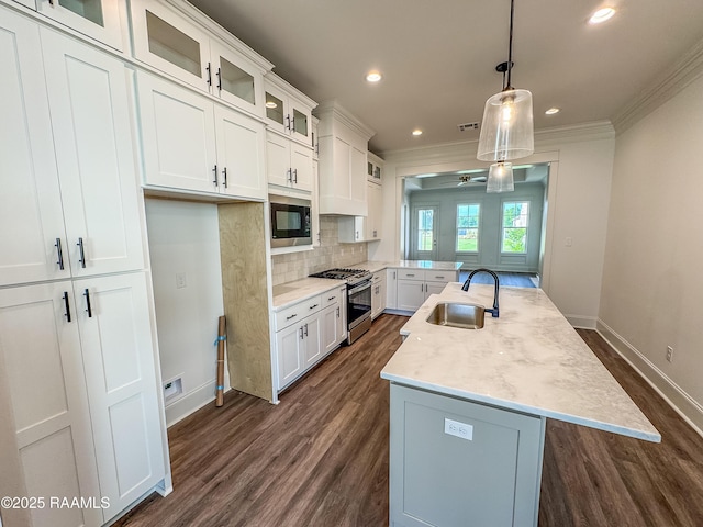 kitchen with ornamental molding, baseboards, built in microwave, stainless steel range with gas stovetop, and a sink
