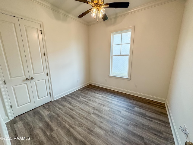 unfurnished bedroom with crown molding, a ceiling fan, baseboards, dark wood-type flooring, and a closet