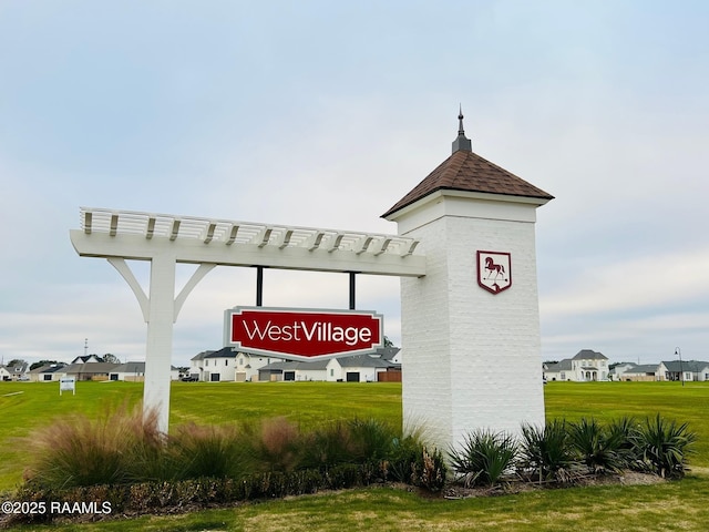 community sign featuring a lawn and a residential view