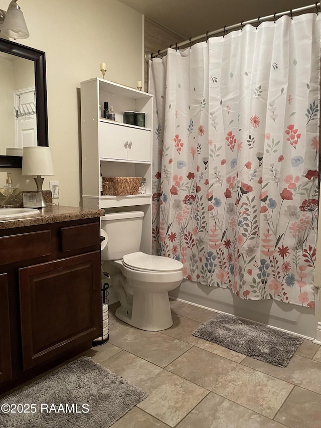 bathroom with toilet, vanity, stone finish floor, and shower / bathtub combination with curtain