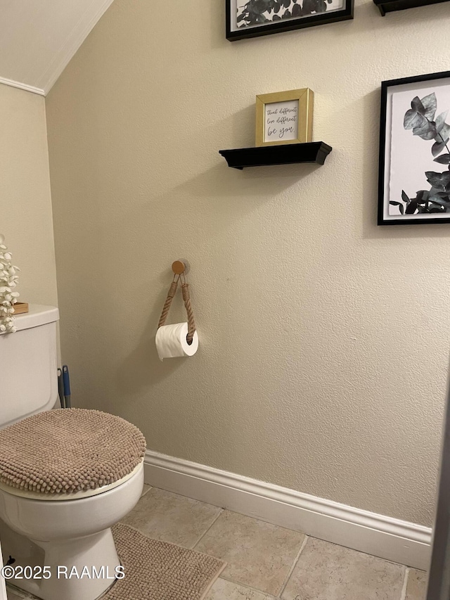 bathroom with tile patterned floors, toilet, baseboards, and ornamental molding