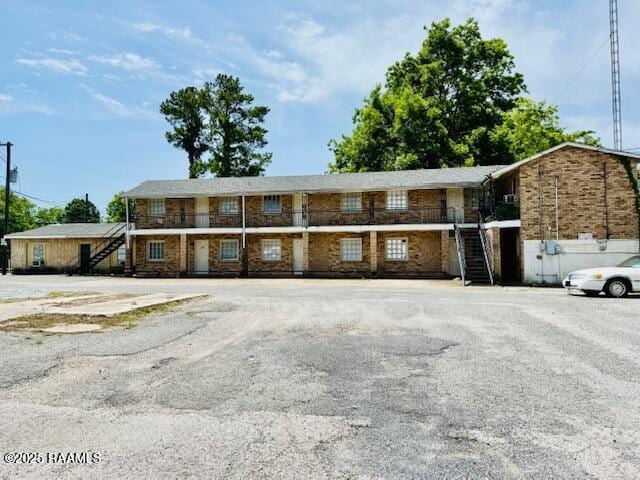 321 S Academy St, Opelousas, LA 70570 - view of front of property with stairs, uncovered parking, and brick siding
