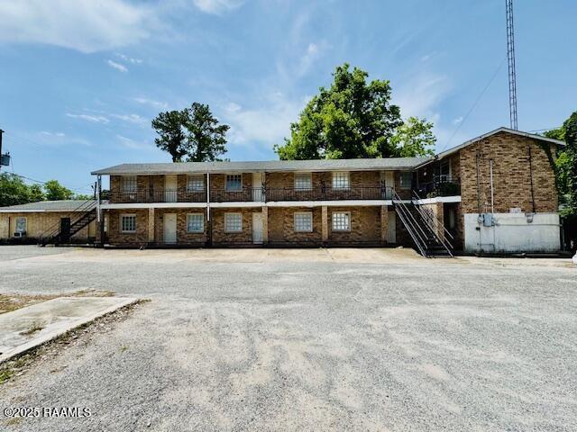 321 S Academy St, Opelousas, LA 70570 - rear view of property with stairs and brick siding