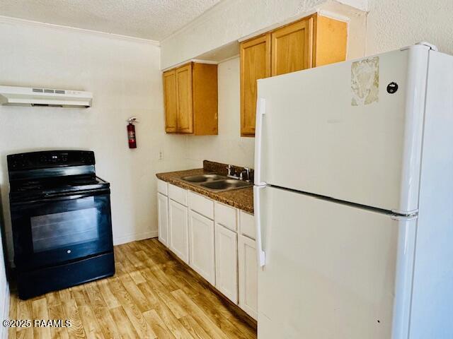 321 S Academy St, Opelousas, LA 70570 - kitchen featuring freestanding refrigerator, black electric range oven, under cabinet range hood, a sink, and dark countertops