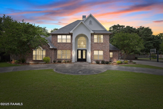 6 Oak Pl, New Iberia, LA 70563 - traditional-style home featuring brick siding, a chimney, french doors, and a front lawn