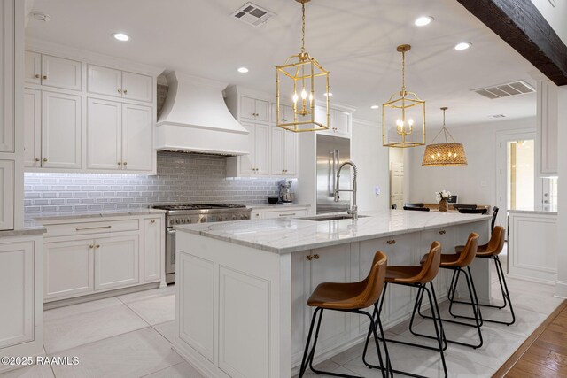 6 Oak Pl, New Iberia, LA 70563 - kitchen with custom exhaust hood, a center island with sink, a sink, backsplash, and premium appliances