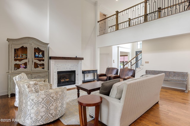 6 Oak Pl, New Iberia, LA 70563 - living room featuring a tiled fireplace, a high ceiling, stairs, and wood finished floors