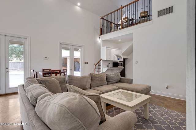 6 Oak Pl, New Iberia, LA 70563 - living room with finished concrete flooring, french doors, baseboards, a towering ceiling, and visible vents