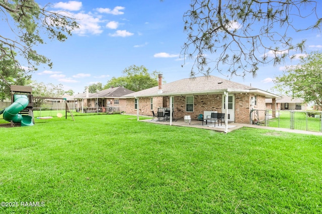 307 Creswell Ave, Scott, LA 70583 - back of property with brick siding, a fenced backyard, a lawn, and a patio