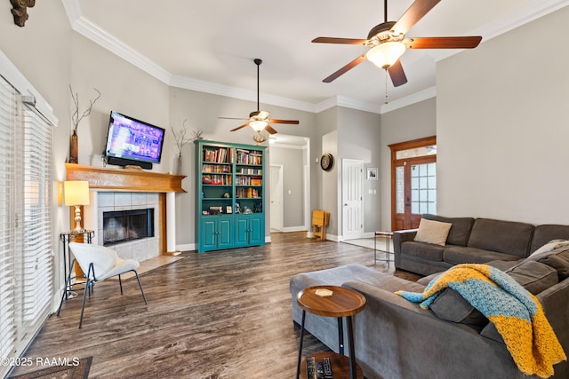 122 Ashford Ln, Youngsville, LA 70592 - living room with ceiling fan, wood finished floors, a tiled fireplace, crown molding, and baseboards