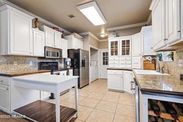 122 Ashford Ln, Youngsville, LA 70592 - kitchen featuring stainless steel appliances, a sink, tasteful backsplash, independent washer and dryer, and crown molding
