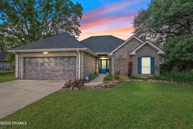 122 Ashford Ln, Youngsville, LA 70592 - view of front of property with an attached garage, roof with shingles, driveway, a lawn, and brick siding