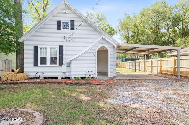 view of front of property with fence, driveway, a front yard, and a carport