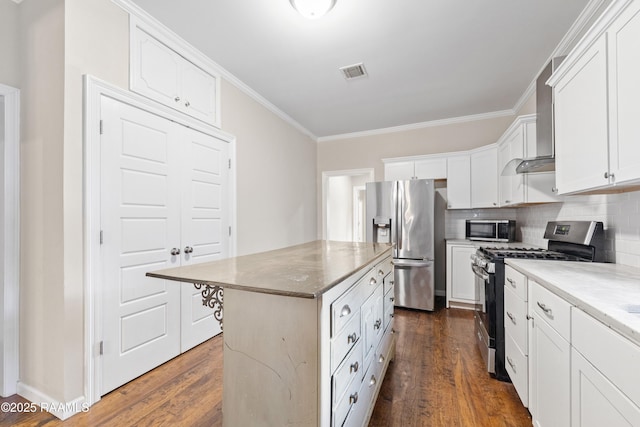 kitchen featuring white cabinets, crown molding, appliances with stainless steel finishes, and dark wood-type flooring