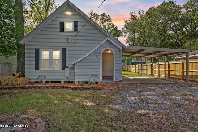 view of front of property featuring fence, an attached carport, driveway, and a front lawn
