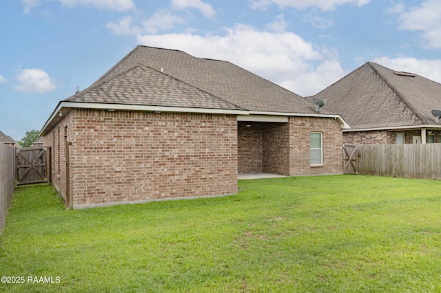 115 Maddox Jude Dr, Maurice, LA 70555 - back of house with a yard, brick siding, a shingled roof, and a fenced backyard