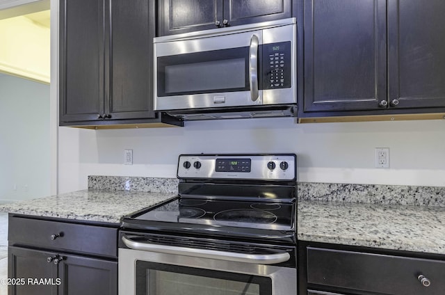 115 Maddox Jude Dr, Maurice, LA 70555 - kitchen with dark cabinetry, light stone countertops, and stainless steel appliances