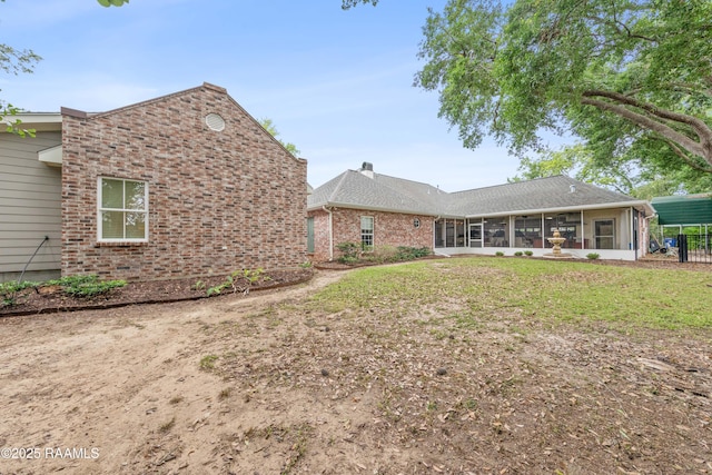 back of property featuring brick siding and a sunroom