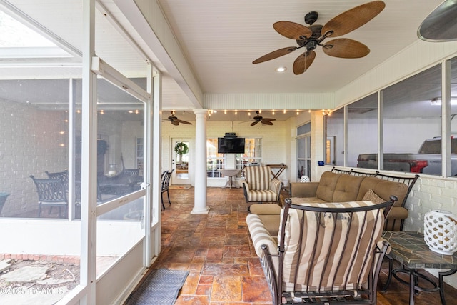 sunroom with ceiling fan and an outdoor living space