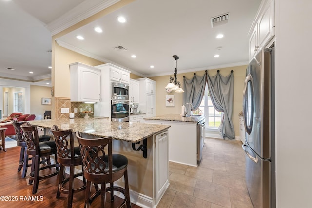 kitchen with recessed lighting, stainless steel appliances, a peninsula, and visible vents