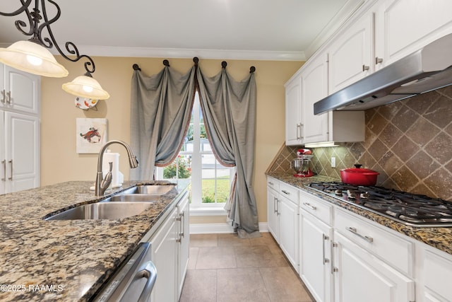 kitchen with under cabinet range hood, white cabinets, a sink, dark stone countertops, and stainless steel appliances
