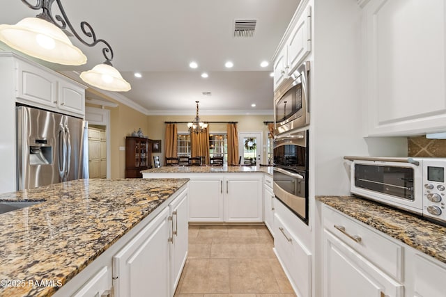 kitchen featuring ornamental molding, stainless steel appliances, white cabinetry, and visible vents