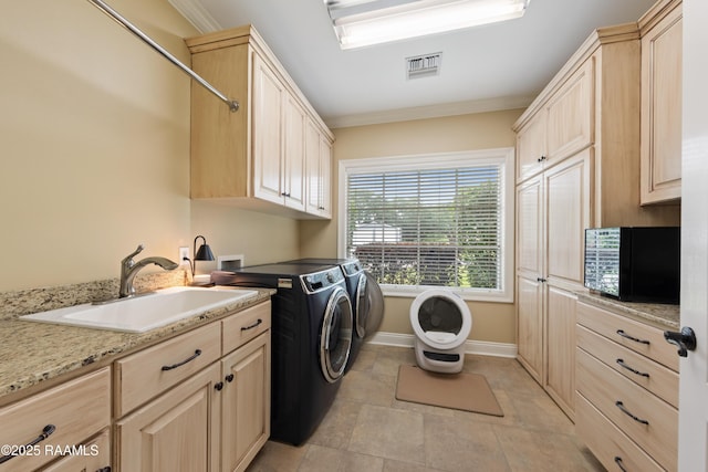laundry room featuring independent washer and dryer, cabinet space, a sink, baseboards, and visible vents