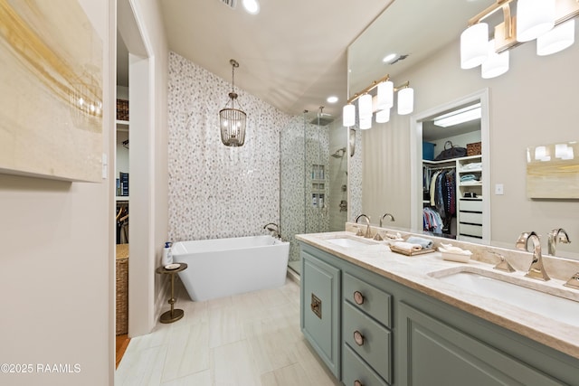 full bathroom with double vanity, a soaking tub, a sink, and a stall shower