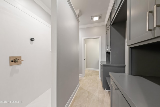 corridor featuring baseboards, visible vents, and ornamental molding