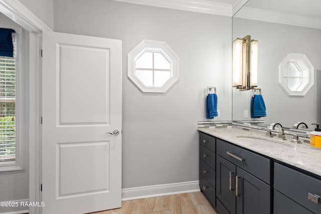 bathroom featuring baseboards, crown molding, and vanity