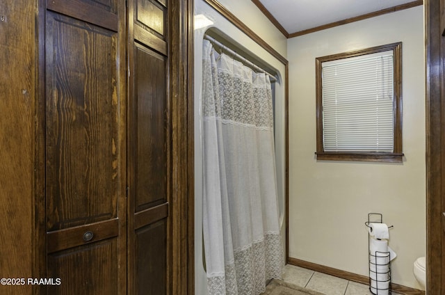 bathroom featuring toilet, ornamental molding, tile patterned floors, a shower with shower curtain, and baseboards