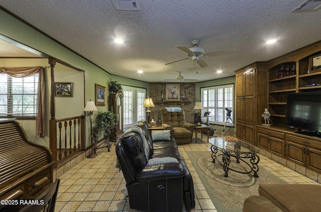 living room featuring ceiling fan, recessed lighting, visible vents, and a textured ceiling